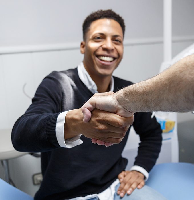 Man shaking hands with dentist after one visit dental restoration