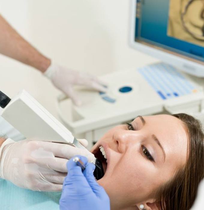 Dentist taking digital impression of patient’s teeth