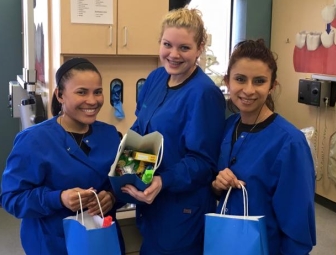 Three dental team members holding gift bats