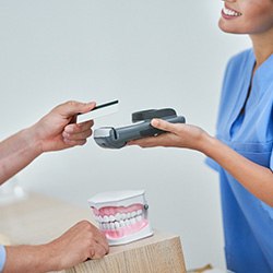 Dental team member accepting payment from patient