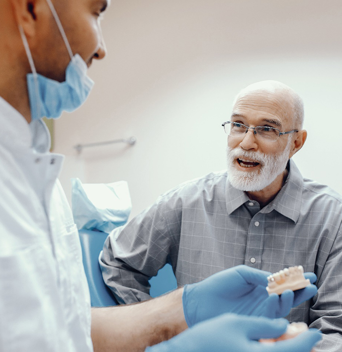 full denture being attached to four dental implants in Barton City 