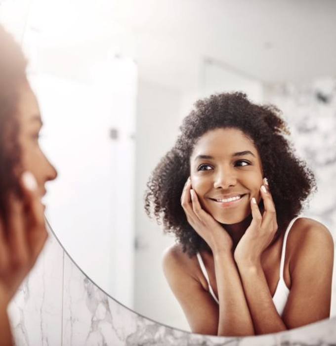 Woman admiring her smile in the mirror