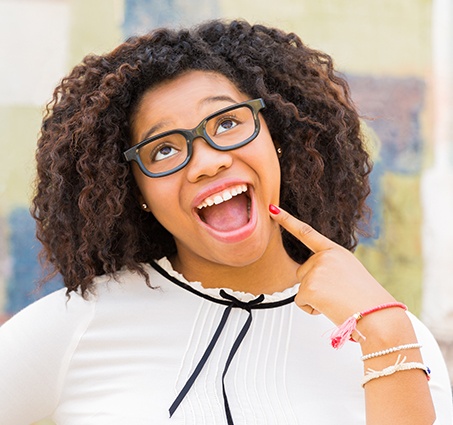 Woman pointing to smile after cosmetic dentistry