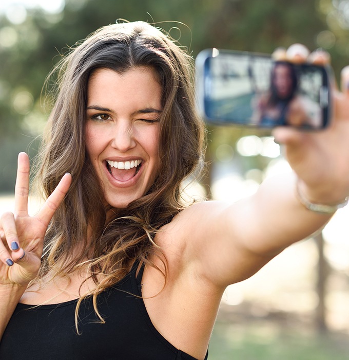 Woman showing off smile after metal free dental restoration