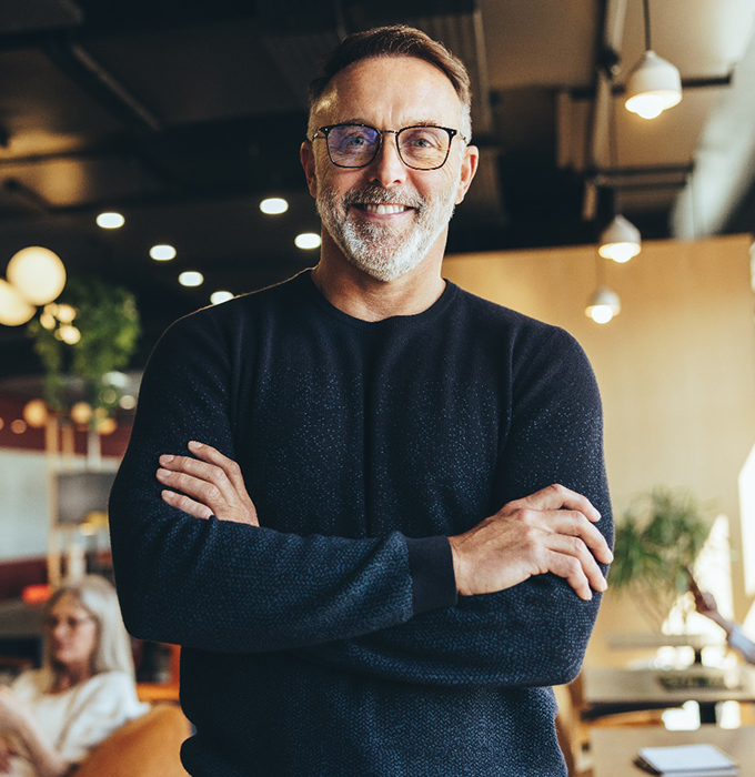 a smiling man with his arms folded