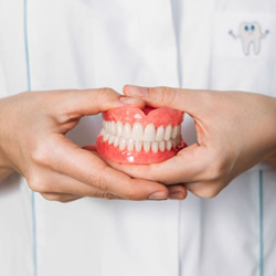 Dental team member holding full set of dentures