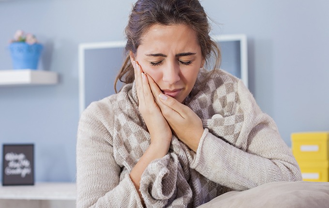 Woman with toothache holding cheek