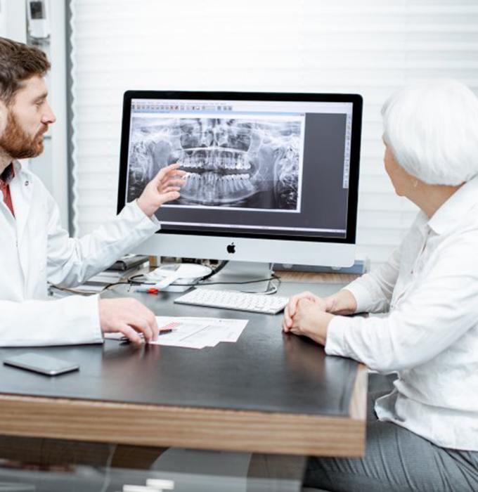implant dentist in Barton City showing a patient their X-rays 