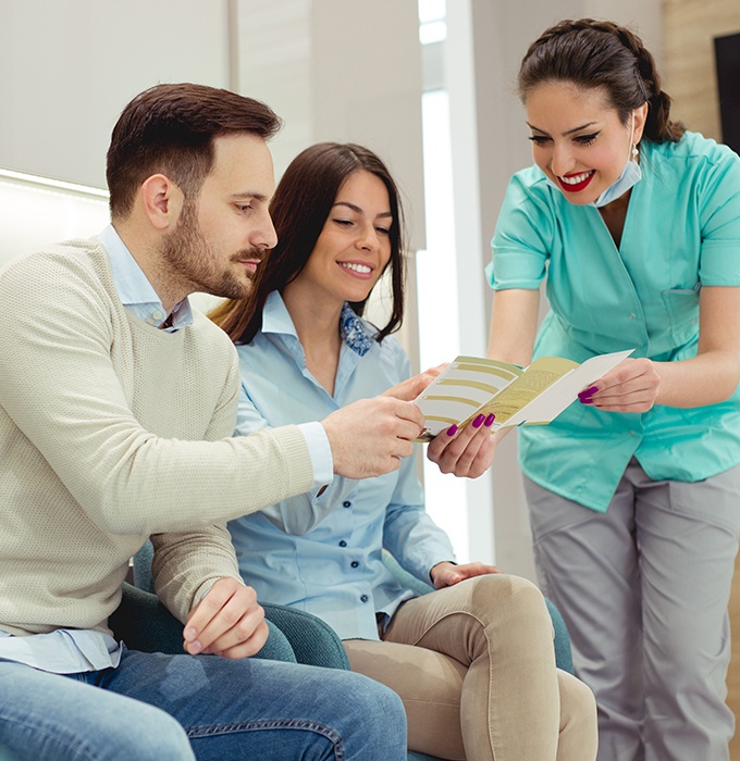 Dental team member showing patients dental insurance forms