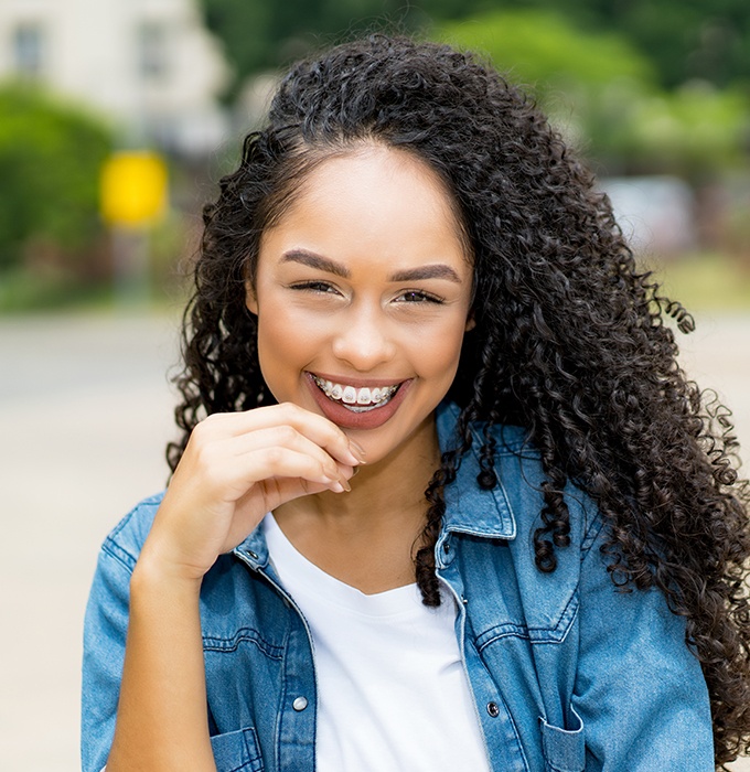 Young woman with traditional orthodontics smiling