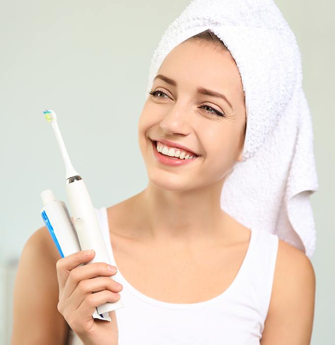 Woman holding toothbrush and toothpaste dental hygiene products