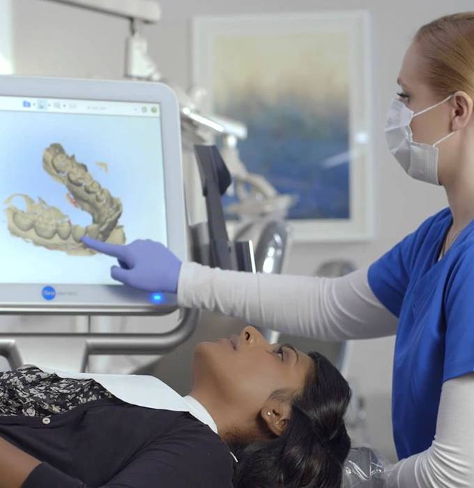 Dental team member and patient looking at intraoral images