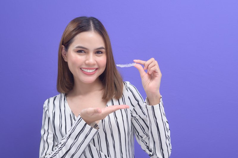 person holding clear aligner trays